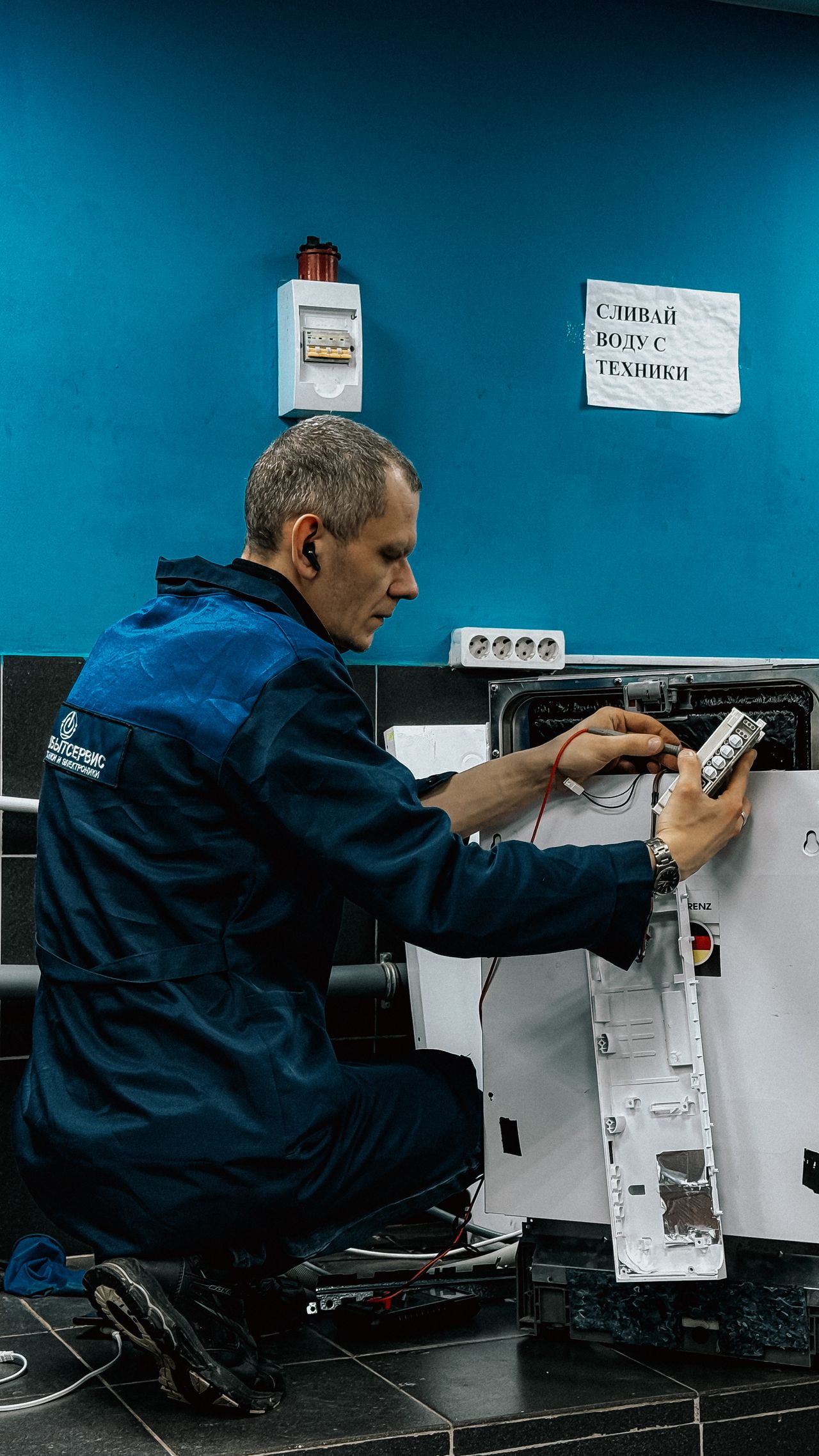 Мастер сервиса ремонтирует бытовую технику